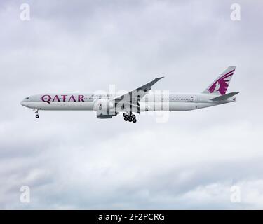 London, Heathrow Airport - März, 2020: Qatar Airways Boeing 777 fliegt durch einen strahlend weißen, aber bewölkten Tag auf dem letzten Anflug nach Heathrow. Bild ab Stockfoto