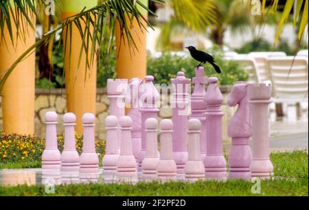 Rook sitzt auf dem König auf einem riesigen Outdoor-Schach Auf der Terrasse eines Resorthotels gelegen Stockfoto