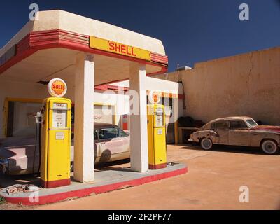 Old Shell Tankstelle in Lowell, Arizona ein alter Cadillac aus den 1950er Jahren unter einem geschützten Überhang. Draußen befindet sich eines von vielen Oldtimern entlang der Erie Street. Stockfoto