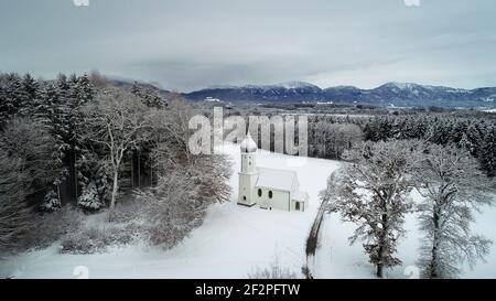 Deutschland, Bayern, Penzberg, verschneite Kapelle am Waldrand. Stockfoto