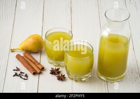 Birnen- und Apfelsaft mit Zimtgeschmack in Glasbecher, Draufsicht Stockfoto