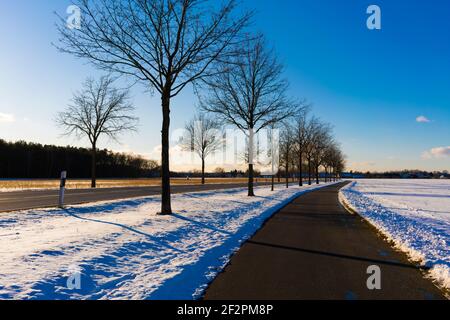 Landstraße Nr. L73 im Winter in Deutschland, zwischen dem Dorf Jaenickendorf und dem kleinen Dorf Holbeck, Gefahr der Glätte durch Schnee für Kraftfahrzeuge Stockfoto