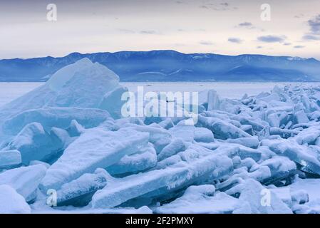Endloses Bummockfeld am gefrorenen Baikalsee. Haufen von schneebedeckten Trümmern von blauem Eis an einem frostigen Tag. Kalter natürlicher Hintergrund. Ungewöhnlicher Winter Stockfoto