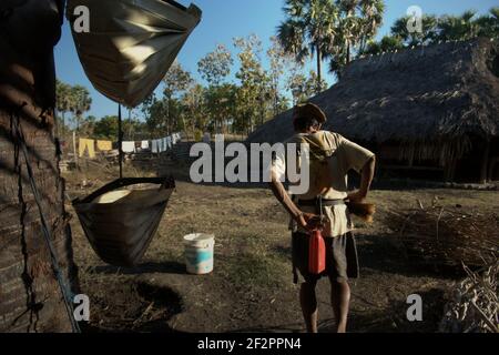 Andreas Mooy geht in Richtung seines Hauses und macht eine Pause vom Sammeln und Transportieren von palmsaft im Dorf Oehandi, Rote Insel, Indonesien. Stockfoto