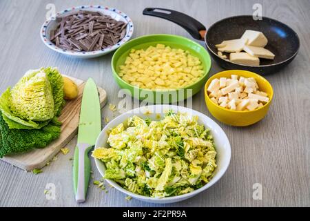 Gewürfelte Kartoffeln, Kohl, Käse, geschmolzene Butter und Knoblauch: Zutaten für die Zubereitung von Pizzoccheri, einem typischen Gericht aus dem Valtellina (Italien) und dem Kanton Graubünden (Schweiz) Stockfoto