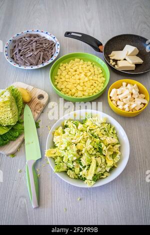 Gewürfelte Kartoffeln, Kohl, Käse, geschmolzene Butter und Knoblauch: Zutaten für die Zubereitung von Pizzoccheri, einem typischen Gericht aus dem Valtellina (Italien) und dem Kanton Graubünden (Schweiz) Stockfoto