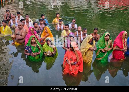 Während des Hindu-Festivals Chhath Puja beten Migranten aus Bihar in N.Indien den sonnengott Suryadav an, der im Wasser des Banganga Tanks, Mumbai, Indien, steht Stockfoto