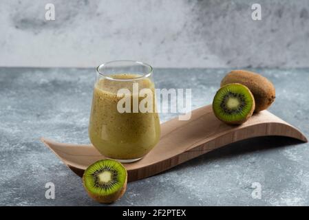 Eine Tasse köstlicher Kiwi-Saft auf einem Holztäfelchen Platine Stockfoto
