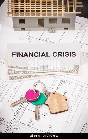 Schlüssel mit Home Form, Währungen Dollar und Inschrift Finanzkrise auf elektrischen Bauzeichnungen. Konzept der Immobilienkrise Stockfoto