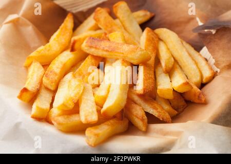 Hausgemachte Ofen gebackene pommes Frites auf Küchenpapier. Schnelle, ungesunde Lebensmittel. Stockfoto