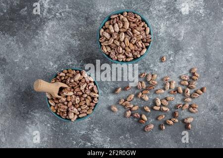 Rohe Bohnenkörner in Schalen auf Marmoroberfläche angezeigt Stockfoto