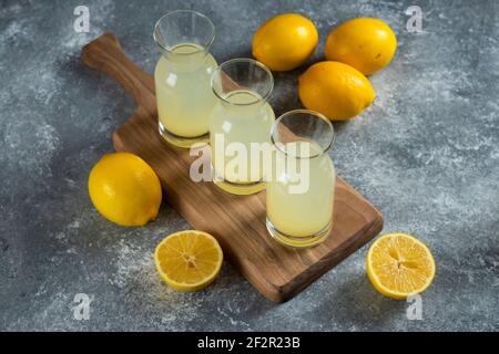 Drei Glaskrüge mit kalter Limonade auf einem Holzbrett Stockfoto