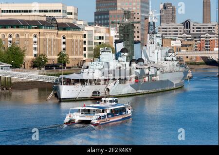 LONDON, Großbritannien - 24. MAI 2010: Tour Boot nähert sich HMS Belfast auf der Themse Stockfoto