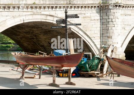 LONDON, Großbritannien - 24. MAI 2010: Traditionelle Holzboote werden neben der Brücke in Richmond upon Thames gebaut Stockfoto