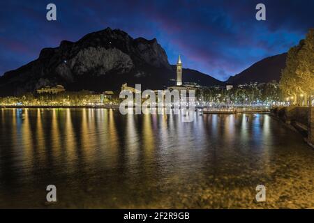 Berühmter Ferienort am Comer See, Italien. Stadt Lecco in der Abenddämmerung mit den Lichtern der Promenade auf dem See reflektiert Stockfoto