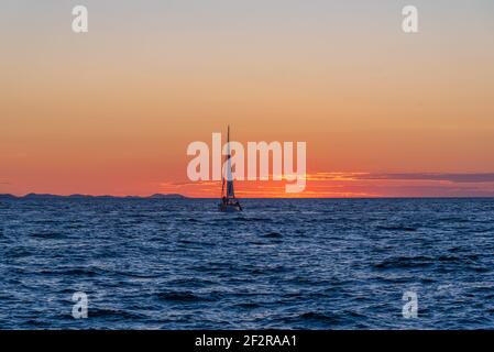 Eine Yacht auf einem ruhigen Meer während des Sonnenuntergangs Stockfoto