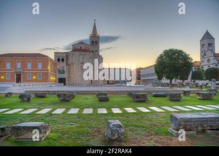 Sonnenaufgang Blick auf Zeleni trg Platz in Zadar mit St. Donatus Kirche, St. Marija Kirche und Archäologisches Museum Stockfoto