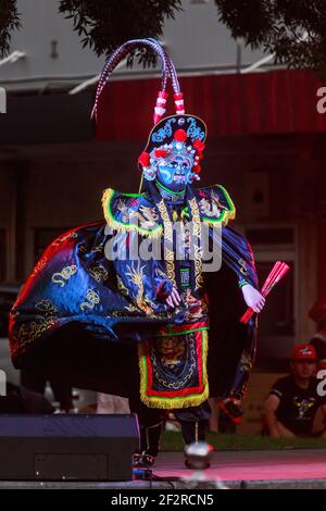 Eine 'bian lian' oder 'face-changing' Tänzerin trägt eine Maske und drachenrobe während der chinesischen Neujahrsfeier Stockfoto