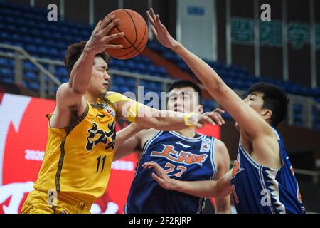 (210313) -- ZHUJI, 13. März 2021 (Xinhua) -- Wu Guanxi (L) von Jiangsu Dragons übergibt den Ball während des 45th Runden Spiels zwischen Jiangsu Dragons und Shanghai Sharks in der Saison 2020-2021 der Chinese Basketball Association (CBA) Liga in Zhuji, Ostchina Zhejiang Provinz, 13. März 2021. (Xinhua/Jiang Han) Stockfoto