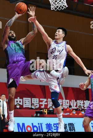 (210313) -- ZHUJI, 13. März 2021 (Xinhua) -- Troy Gillenwater (L) von Shandong Heroes erschießt Zhu Songwei von Sichuan Blue Whales während des 45th Runden Spiels zwischen Shandong Heroes und Sichuan Blue Whales in der Saison 2020-2021 der Chinese Basketball Association (CBA) Liga in Zhuji, Ostchina Zhejiang Provinz, 13. März 2021. (Xinhua/Hu Huhu) Stockfoto