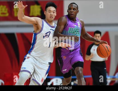 (210313) -- ZHUJI, 13. März 2021 (Xinhua) -- Lester Hudson (R) von Shandong Heroes dribbelt gegen Jing Hanyi von Sichuan Blue Whales während des 45th Runden Spiels zwischen Shandong Heroes und Sichuan Blue Whales in der Saison 2020-2021 der Chinese Basketball Association (CBA) Liga in Zhuji, Ostchina Zhejiang Provinz, 13. März 2021. (Xinhua/Hu Huhu) Stockfoto