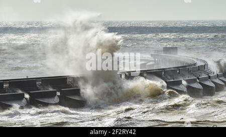 Brighton UK 13th March 2021 - riesige Wellen brechen über Brighton Marina ab, als starke Winde heute wieder die Südküste schlagen : Credit Simon Dack / Alamy Live News Stockfoto