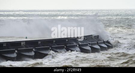 Brighton UK 13th March 2021 - riesige Wellen brechen über Brighton Marina ab, als starke Winde heute wieder die Südküste schlagen : Credit Simon Dack / Alamy Live News Stockfoto