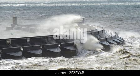 Brighton UK 13th March 2021 - riesige Wellen brechen über Brighton Marina ab, als starke Winde heute wieder die Südküste schlagen : Credit Simon Dack / Alamy Live News Stockfoto