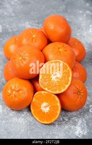 Saftige orange Früchte mit Scheiben auf Stein Hintergrund Stockfoto