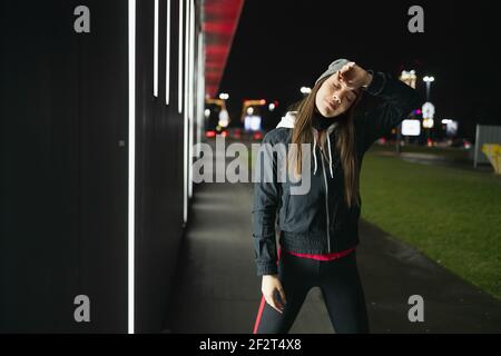 Die lächelnde während bereitet sich auf eine Nacht laufen um die Stadt Stockfoto