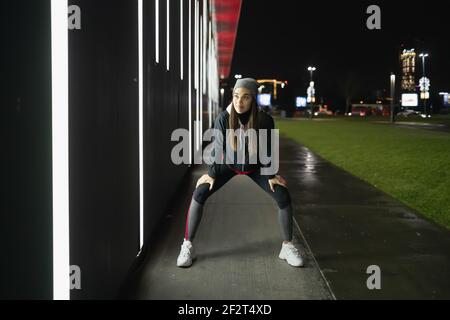 Die lächelnde während bereitet sich auf eine Nacht laufen um die Stadt Stockfoto