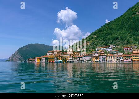 Blick vom See Iseo auf eine kleine Stadt am Insel Monte Isola Sulzano Stockfoto