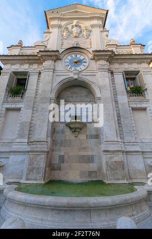 Der alte Travertinbrunnen mit Uhr in Spoleto (Fontana di Piazza del Mercato) Spoleto, Umbrien, Italien Stockfoto