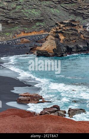 Detail des Strandes El Golfo auf Lanzarote, Kanarische Inseln. Schwarzer Sandstrand aufgrund vulkanischer Aktivität Stockfoto