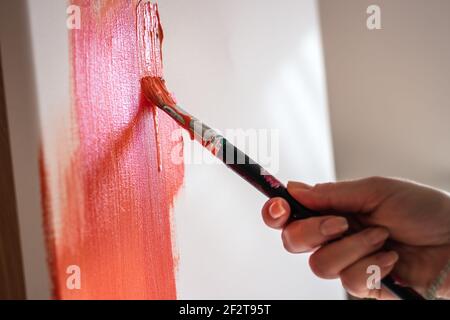 Acrylmalerei. Nahaufnahme weibliche Hand mit Pinsel Farbe auf Leinwand. Arbeiten im Kunststudio Stockfoto