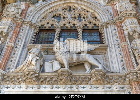 Marmordekoration des Eingangs (Porta della Carta) des Dogenpalastes (Palazzo Ducale) mit dem Symbol von Venedig, dem geflügelten Löwen. Markusplatz (P Stockfoto