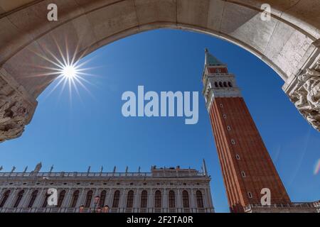 Blick vom Bogen des Dogenpalastes (Palazzo Ducale) auf den berühmten Glockenturm des Hl. Markus (Campanile di San Marco). Venedig, Italien Stockfoto