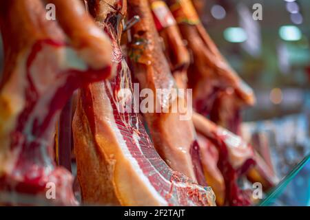 Jamon. Ein spanischer Schinken auf dem Lebensmittelmarkt in Barcelona. Selektiver Fokus. Bokeh. Stockfoto