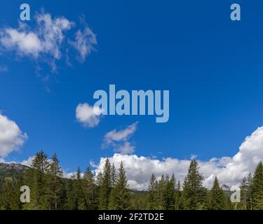 Schöner blauer Himmel mit strukturierten Wolken und Berggipfeln entlang Die Unterseite des Bildes Stockfoto