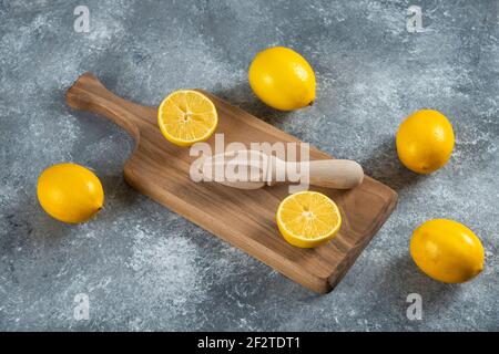 Geschnittene und ganze Zitronen mit Holzreiher Stockfoto