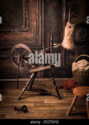 Stillleben Bild von einem authentischen alten Spinnrad mit Echte Schafwolle Stockfoto