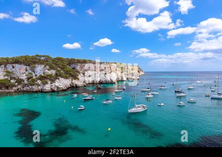 Blick auf die schönste Bucht Cala Macarella der Insel Menorca mit smaragdgrünem Wasser und vielen Yachten am Meer. Balearen, Spanien Stockfoto