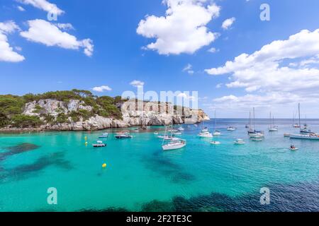 Blick auf die schönste Bucht Cala Macarella der Insel Menorca mit smaragdgrünem Wasser und vielen Yachten am Meer. Balearen, Spanien Stockfoto