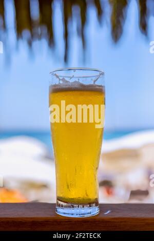 Ein Glas kaltes Bier an einer Strandbar (Vertikales Foto) Stockfoto