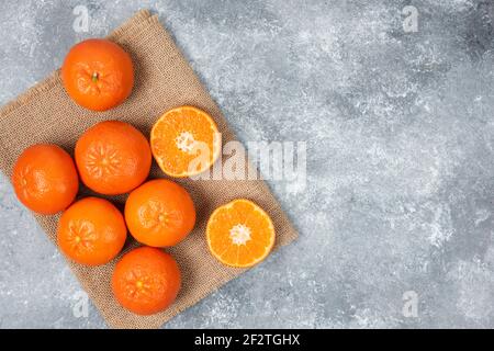 Saftige orange Früchte mit Scheiben auf Stein Hintergrund Stockfoto