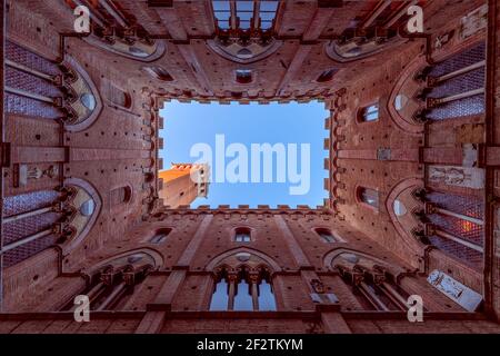 Weitwinkelansicht vom Innenhof des Palazzo Pubblico auf den berühmten Torre del Mangia. Siena, Toskana, Italien Stockfoto