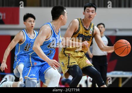 (210313) -- ZHUJI, 13. März 2021 (Xinhua) -- Wang Ziqi (R) von Nanjing Monkey Kings übergibt den Ball während des 45th-Runden-Spiels zwischen Nanjing Monkey Kings und Beijing Ducks in der Saison 2020-2021 der Chinese Basketball Association (CBA) Liga in Zhuji, Ostchina Zhejiang Provinz, 13. März 2021. (Xinhua/Hu Huhu) Stockfoto