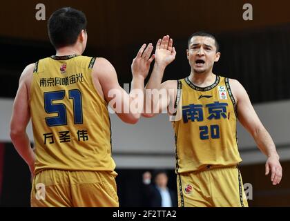 (210313) -- ZHUJI, 13. März 2021 (Xinhua) -- Xiralijan Muhtar (R) von Nanjing Monkey Kings High-Fives mit Teamkollege Wan Shengwei während der 45th Runde Spiel zwischen Nanjing Monkey Kings und Beijing Ducks in der Saison 2020-2021 der Chinese Basketball Association (CBA) Liga in Zhuji, Ostchina Zhejiang Provinz, 13. März 2021. (Xinhua/Hu Huhu) Stockfoto