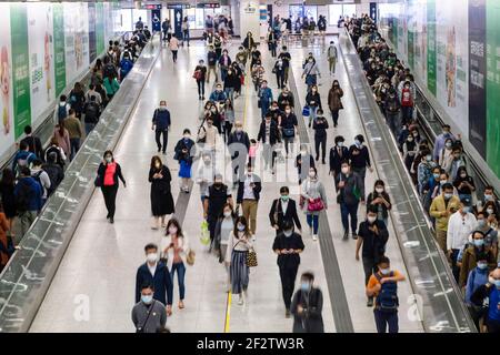 Pendler mit Gesichtsmasken als vorbeugende Maßnahme gegen die Ausbreitung des Coronavirus Covid-19 gehen durch die Central MTR Station.Hongkong hat eine Spitze von neuen Coronavirus (Covid-19) Infektionen gemeldet, wobei die Mehrheit von ihnen mit dem Cluster verbunden ist, der in einem Fitnessstudio im Bezirk Sai Ying Pun stammt. Stockfoto