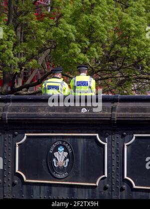 Zwei Metropolitan-Polizisten in Hi-viz-Jacken, die auf einer Brücke über den Regents Canal, Camden, London, Großbritannien, mit Kopierraum stehen Stockfoto